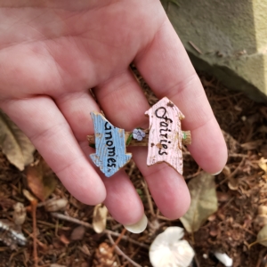 Amber's hand holding broken fairies and gnomes sign