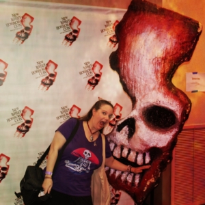 Amber being "eaten" by the statue of the NJ Horror Con logo which has a skull inside the state shape.