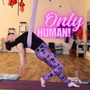Amber in quad stretch backbend against aerial silk with text "only human"