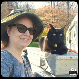 Amber outside wearing the expensive eyeglasses as she stands next to Gus who is lying on a metal crate enjoying the fresh air.