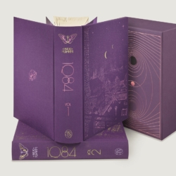 book open showing the spine on top of second volume, in front of the slipcase, First Ever Illustrated Edition of Haruki Murakami’s 1Q84, Featuring Beautifully Surreal Artwork by Acclaimed Series Artist Daniel Liévano