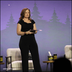 Angenette Levy standing on the stage at CrimeCon