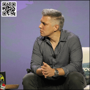 Brian Entin, leaning forward with his elbows on his thighs, looking to his right with his brows furrowed as he listens to Melissa Smith or Hailey Smith during interview.