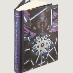 The Binti Trilogy collection shown in hardcover as one book from the Folio Society; book is standing up to show the metallic blue letters of the spine and the art for the front cover.