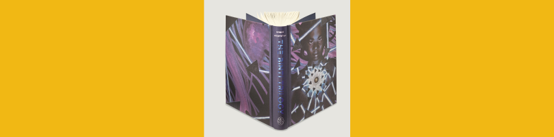 The Binti Trilogy collection shown in hardcover as one book from the Folio Society; book is standing up to show the metallic blue letters of the spine and the art for the back and front covers.