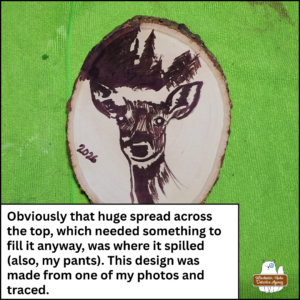 close up of the wooden deer plaque in progress after the heat gun was applied to the Scorch Marker ink; caption: Obviously that huge spread across the top, which needed something to fill it anyway, was where it spilled (also, my pants). This design was made from one of my photos and traced.
