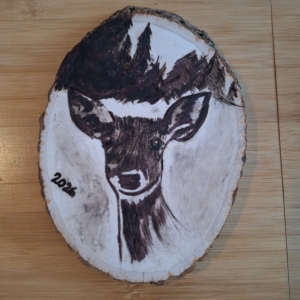 close up of the wooden deer plaque in progress after the wood burning iron was used to make shading.