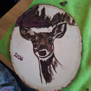 close up of the wooden deer plaque in progress after the heat gun was applied to the Scorch Marker ink.