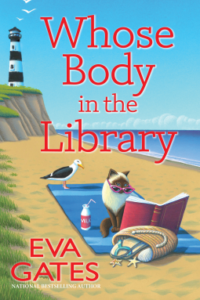 A lighthouse in the background on a cliff overlooking a beach where a seagull and Himalayan chocolate point cat sit on a beach blanket with an open book, a bag of sandals, a bottle of milk with a straw, the cat is wearing pink reading glasses. Red text: Whose Body in the Library, Eva Gates, national bestselling author